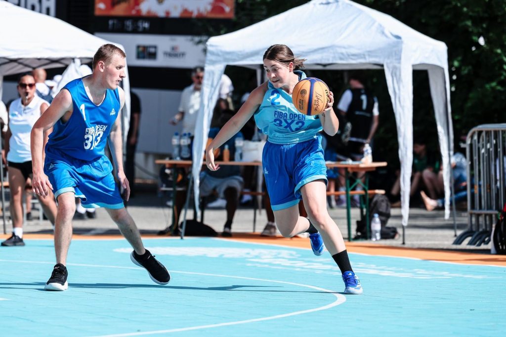 Two basketball players in blue play on a blue court